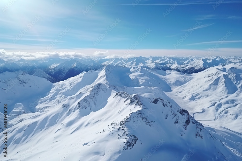 Aerial view of an untouched snowy mountain range under clear blue skies Aerial view of an untouched snowy mountain range under clear blue skies