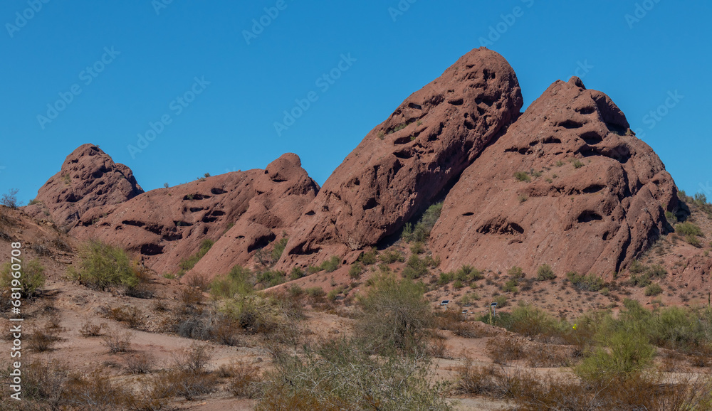 landscape in the desert of large boulders with bushes in foreground