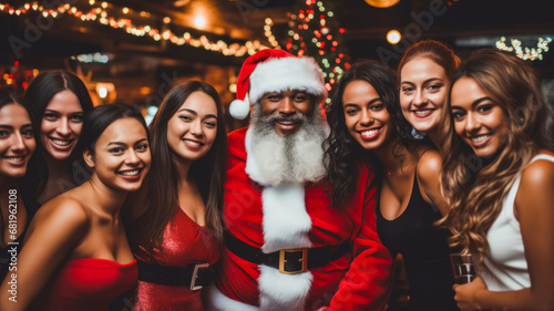 Group of people in Santa Claus hats celebrating in the nightclub with blurry defocused Christmas tree and bokeh lights background.
