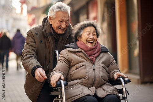 Elderly man pushing senior woman in wheelchair.