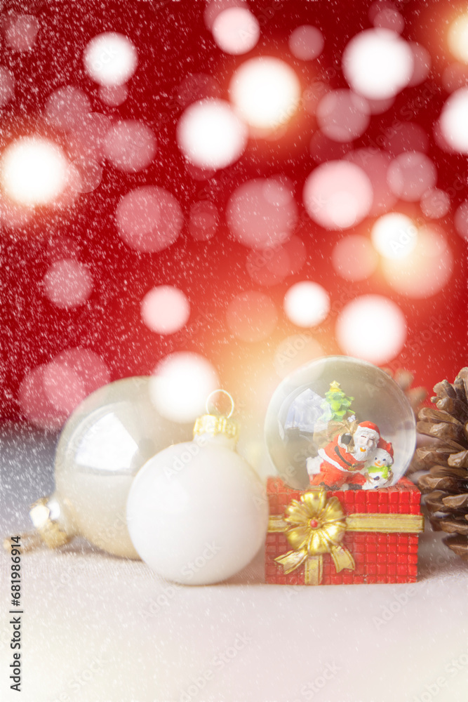 Christmas balls, Santa Claus in a Snow globe, and Pine cones on a Cream-Colored Cloth, set Against a Red Background and exquisite bokeh. New Year Celebration Atmosphere, about of Important day.