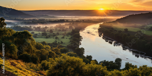 First light of sunrise over a river, seen from a hill's vantage point