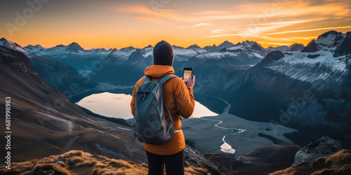 Female traveler snapping a photo of mountain scenery with her mobile