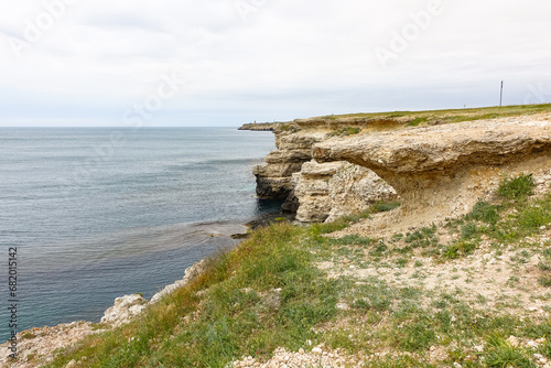 Cape Tarkhankut on the Crimean peninsula. The rocky coast of the Dzhangul Reserve in the Crimea. The Black Sea. Turquoise sea water. Rocks and grottoes of Cape Tarkhankut. photo