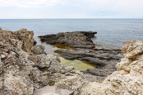 Cape Tarkhankut on the Crimean peninsula. The rocky coast of the Dzhangul Reserve in the Crimea. The Black Sea. Turquoise sea water. Rocks and grottoes of Cape Tarkhankut. photo