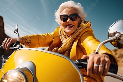 A joyful and happy elderly woman on a yellow scooter rides at a speed down the street in the city. Happiness from movement on a sunny day is generated by AI.