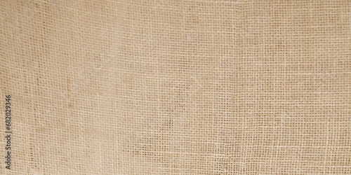 Jute hessian sackcloth woven organic burlap, hemp flax texture pattern background in light cream yellow beige brown color