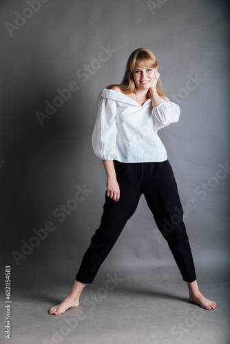 Beautiful young woman in white blouse and black pants