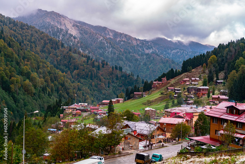Rize, Ayder Plateau, Turkey. Chalets in the forest covered with yellow and orange leaves in autumn. With its misty air covered with clouds and pristine nature.