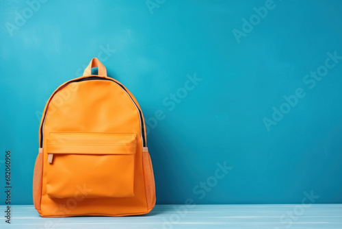 Orange school backpack on blue background