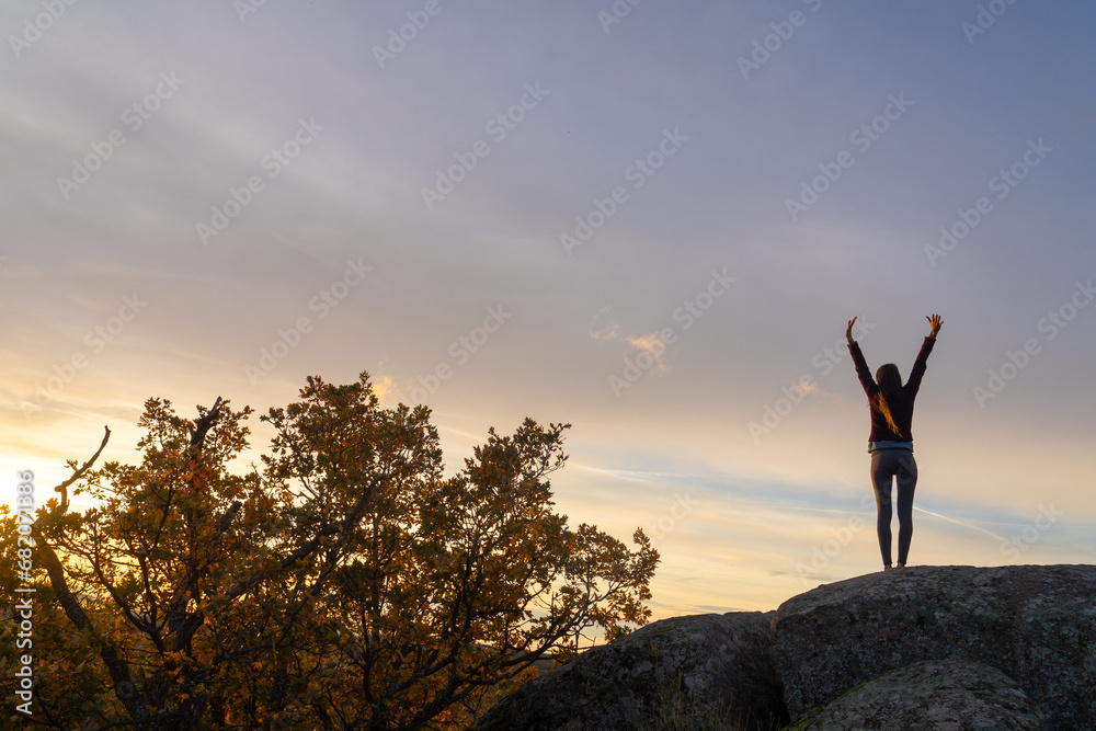Woman on top of a mountain stretching at sunrise Woman on top of a mountain stretching at sunrise
