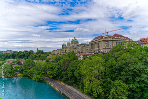 Scenic view of Swiss Federal Palace with Aare River in the foreground on a cloudy summer day at Bern, Capital of Switzerland. Photo taken July 1st, 2023, Bern, Switzerland. © Michael Derrer Fuchs