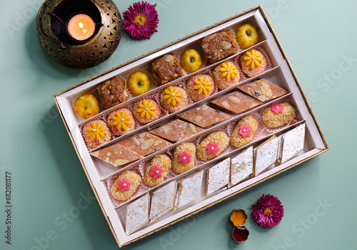 Indian assorted Diwali sweets or mithai box with diya and flowers. Festive gift idea. Kaju katli, dry fruits peda, barfi, cashew nut barfi, marzipan, khoya cakes. christmas box. copy space.