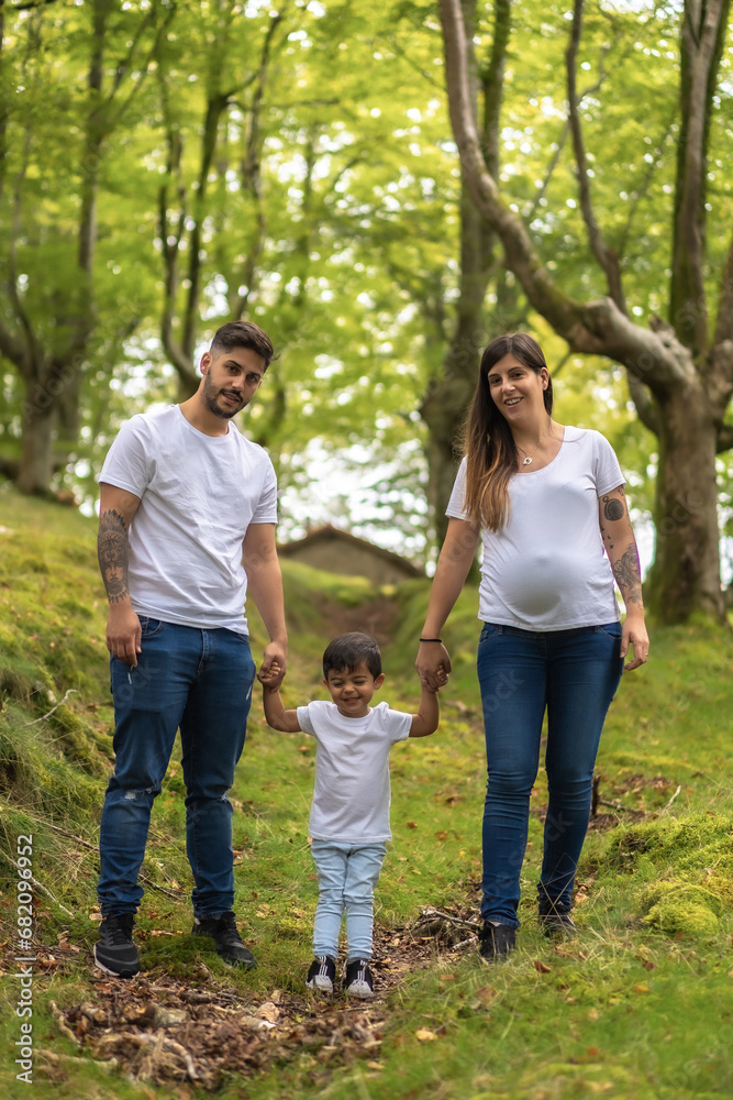 Pregnant mother with family standing in a beauty forest
