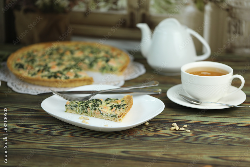Delicious Quiche pie with salmon fish and pine nuts filling. Breakfast with quiche and cup of tea Delicious Quiche pie with salmon fish and pine nuts filling. Breakfast with quiche and cup of tea