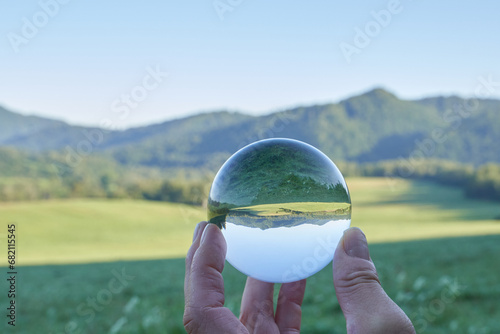 Beautiful landscape of the Carpathian Mountains in Poland, a sunny day with a meadow and green, flowered mountains, seen through a crystal ball that goes around the landscape, in Europe