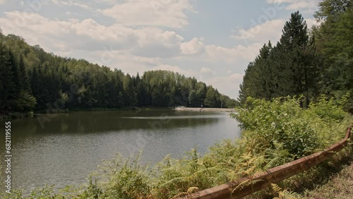 Capturing lake Radalj in Serbia, woods surrounding it and blue cloudy sky photo