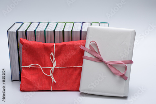 Książki zapakowane na prezent w papier pakowy, owinięte wstążką z kokardą