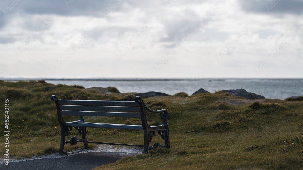 A special place: bench standing close to the beach with a view over the ocean, moody scene A special place: bench standing close to the beach with a view over the ocean, moody scene
