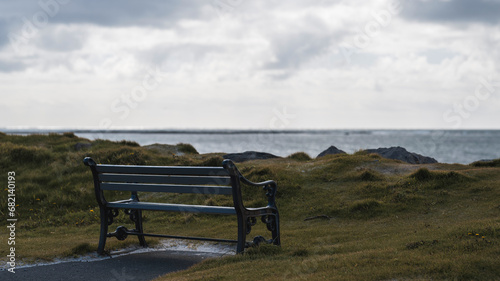A special place: bench standing close to the beach with a view over the ocean, moody scene