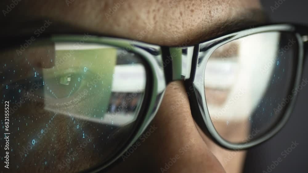 A binary code of zeros and ones is reflected on the glasses on a man's face. The idea of a digital future. Data concept.