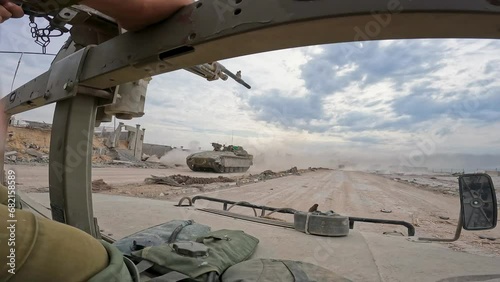 A Humvee speeding through war-torn Gaza as Namer APC heads in opposite direction photo