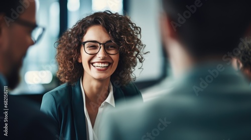 Joyful corporate team engaging in a light-hearted conversation in an office setting, with a focus on a woman laughing amongst her colleagues. AI generated