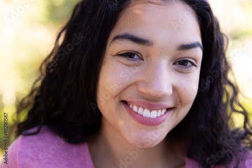 Close up portrait of happy biracial woman in sunny nature