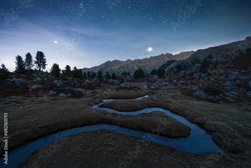 Scenic view of a serpentine stream winding through a meadow at night, shot in Siviez Nendaz photo
