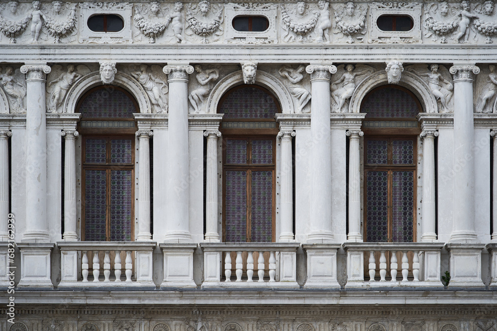 Tall windows in gothic style on the Doge's Palace (Italian: Palazzo Ducale), one of the main Venetian landmarks. Venice - 5 May, 2019