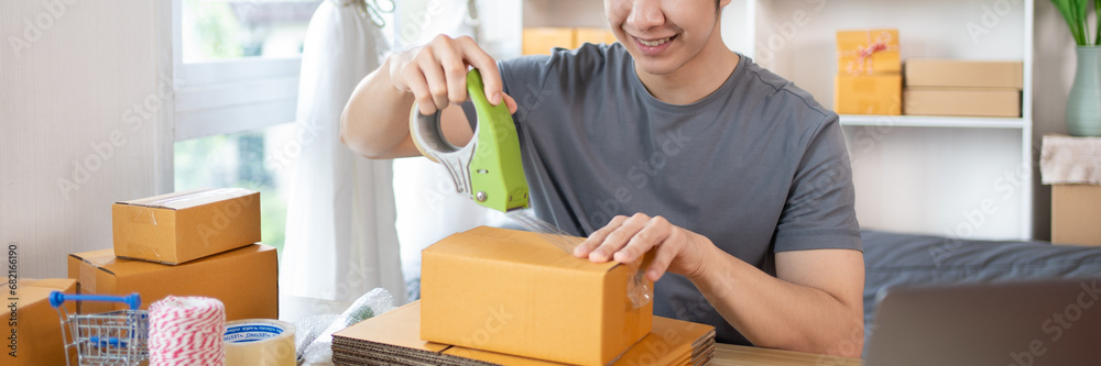 Efficient Home-Based Delivery, Man Packing Items into Post Box for Customer Shipping, Online Shopping and Small Business Entrepreneurship, Packing box, Sell online, Freelance working. Efficient Home-Based Delivery, Man Packing Items into Post Box for Customer Shipping, Online Shopping and Small Business Entrepreneurship, Packing box, Sell online, Freelance working.