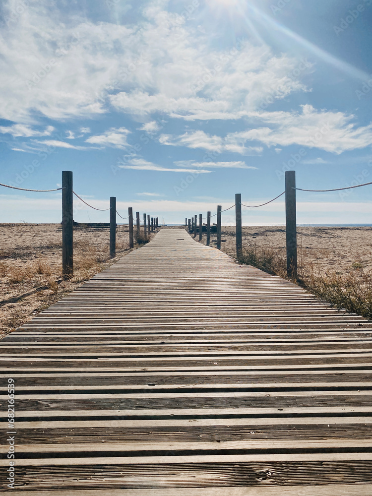 Obraz premium Wooden path on the beach to reach the sea.