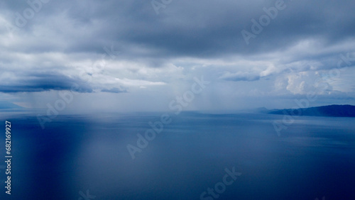 Thunderclouds and rain over the sea. Aerial view of rain over the sea on the horizon.