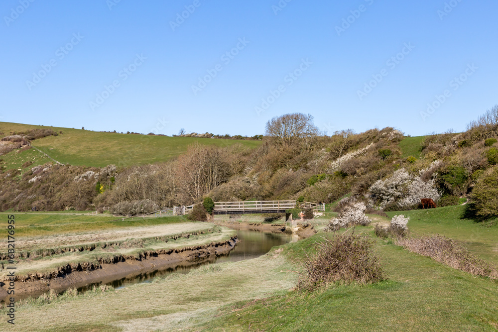 A rural Sussex view of the Cuckmere River, with a blue sky overhead