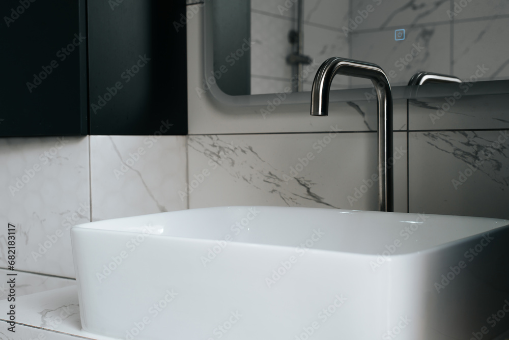 Faucet with white sink, bathroom close-up minimalism