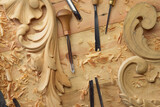 Hands of craftsman carve with a gouge in the hands on the workbench in carpentry. Wood carving tools close-up top view
