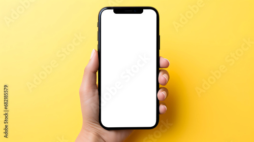 hand holding smartphone on yellow background blank screen mockup