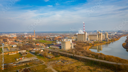 Aerial view of industrial complex thermal power plant with tall chimney in winter