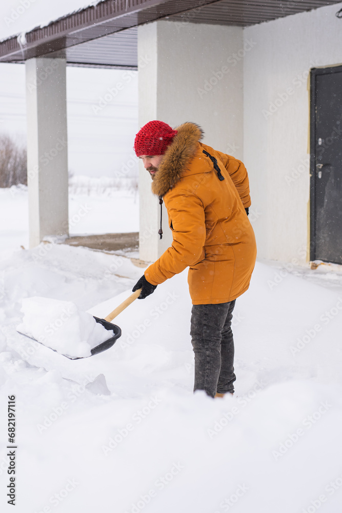 Man removing snow and ice from the sidewalk in front of house. Winter season Man removing snow and ice from the sidewalk in front of house. Winter season