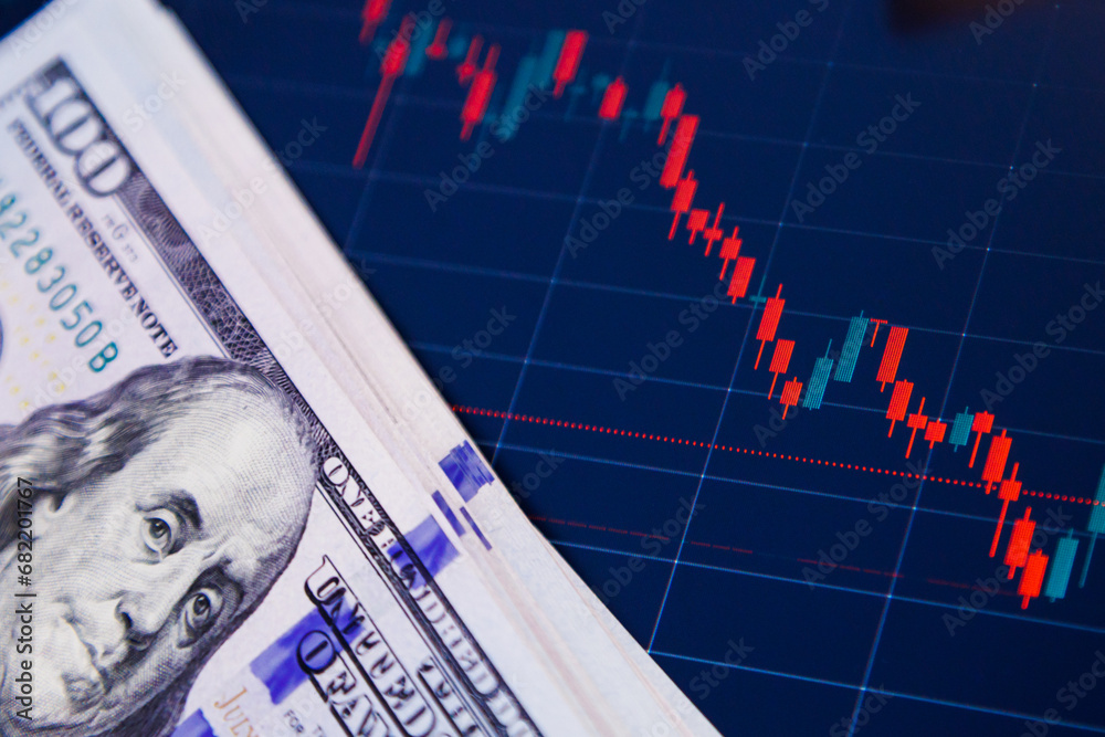 US dollar banknotes over digital screen with exchange chart ...