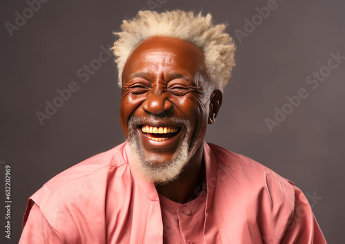 Happy senior black man in pink shirt on grey background