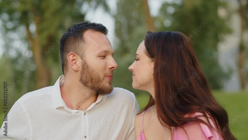 Mid shot young couple biting grape on picnic and kisses. Cute wife kiss husband after feeds him a sweet grape in nature. Beautiful family couple having romantic date lunch outdoors Mid shot young couple biting grape on picnic and kisses. Cute wife kiss husband after feeds him a sweet grape in nature. Beautiful family couple having romantic date lunch outdoors