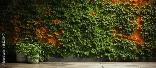 In an abstract design, the textured wallpaper showcased an intricate blend of ivy leaves and grass, transforming the wall into a natural oasis of green and orange, reminiscent of a lush garden in a
