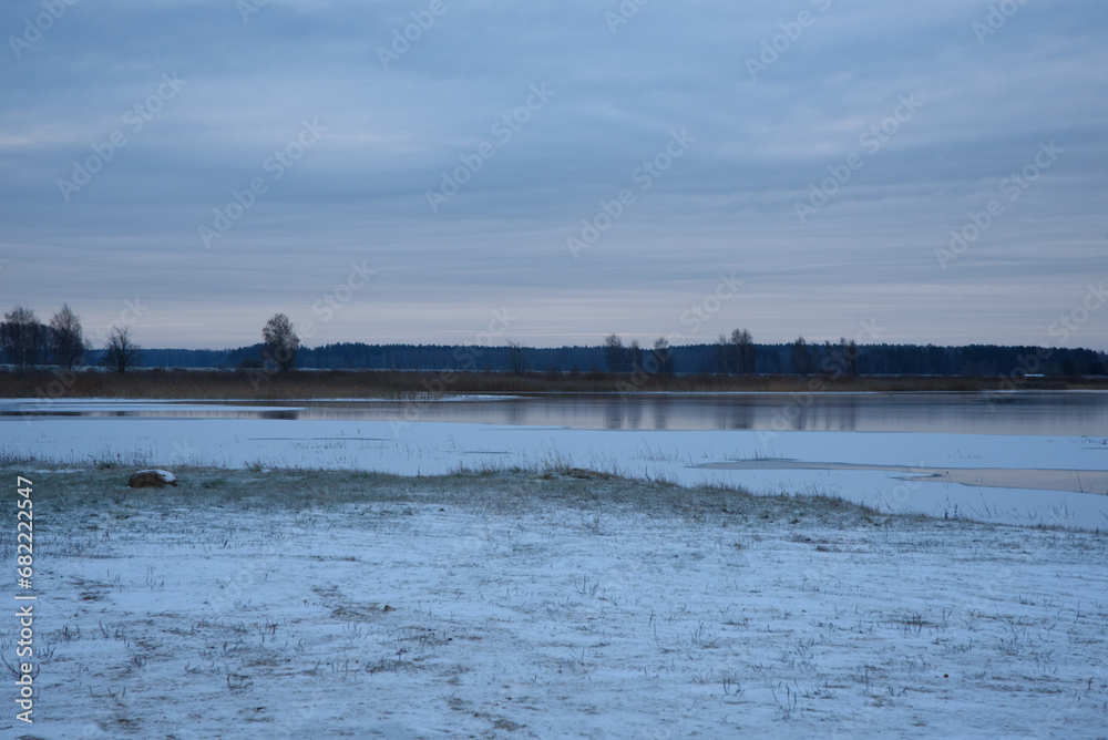 lightly snow-covered lake during the first frost