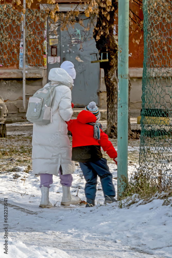 Children walk along the sidewalk on a winter day