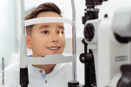 Smiling Caucasian boy receiving eye exam at clinic photo