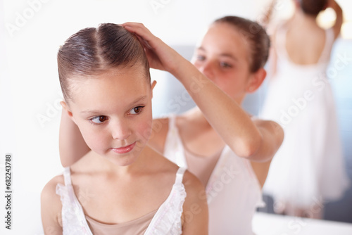 Ballet, children and help with hair in studio, academy or gym, dancer friends training together. Young girl ballerina students in dance class with support, trust and learning practice for performance