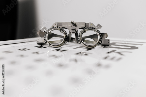 Image of test glasses with letter diagram for eye examination, vision optometry background. Vision diagnostics and prevention concept.