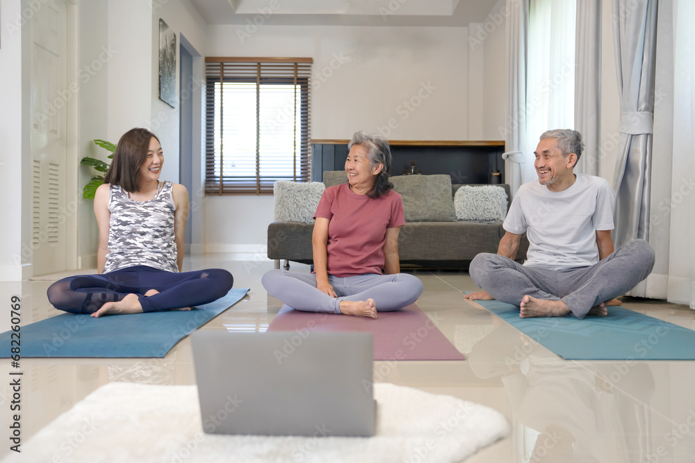 happy asian family doing fitness training together,father,mother and young adult daughter is laughing while doing yoga at home happy asian family doing fitness training together,father,mother and young adult daughter is laughing while doing yoga at home