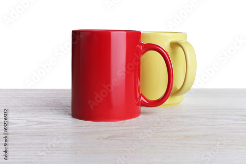 Ceramic mugs on wooden table against white background